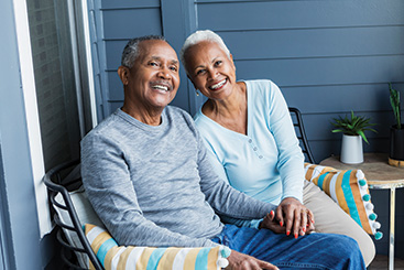A couple sitting on a bench together. Links to Ages 60-70