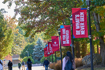 Students walking past lightposts with school banners. Links to Gifts of Cash, Checks, and Credit Cards